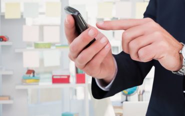 Persoană care folosește telefonul pentru reîncărcarea online a unei cartele Digi